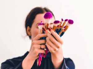 vrouw met make-up kwasten (net kunst: de Emoji make-up challenge op Tiktok )